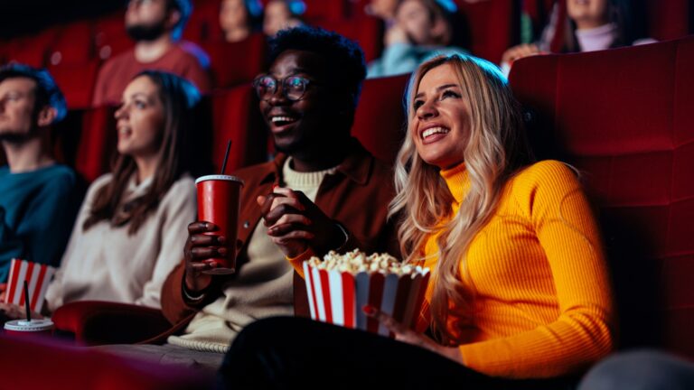 Moviegoers watching a superhero film in a theater.