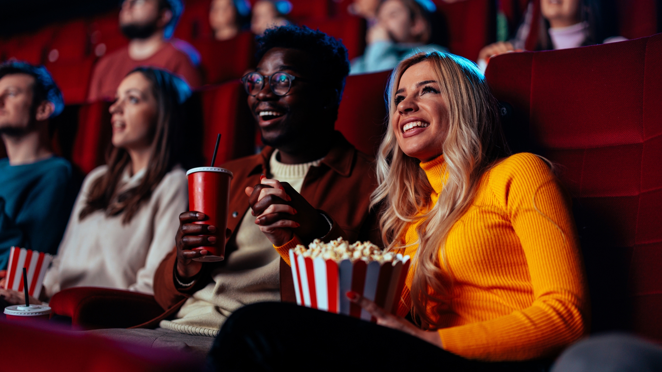 Moviegoers watching a superhero film in a theater.